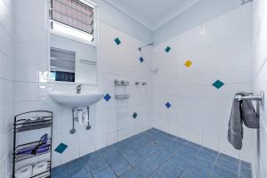 埃尔利海滩Airlie Sun & Sand Accommodation #2的带水槽和淋浴的白色浴室 更多8张照片