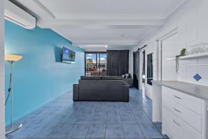 埃尔利海滩Airlie Sun & Sand Accommodation #3的客厅里有一张沙发和一张桌子。