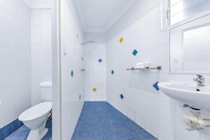 埃尔利海滩Airlie Sun & Sand Accommodation Studio #1的带马桶和水槽的白色浴室