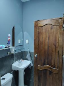 Un baño con puerta de madera y lavabo. en Departamento Elegante y acogedor hotel Económico, en La Libertad 7 fotos más