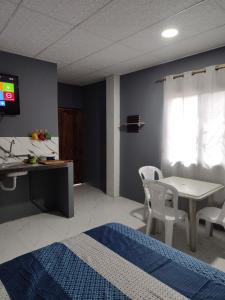 una habitación con una cama, una mesa y sillas en Departamento Elegante y acogedor hotel Económico, en La Libertad