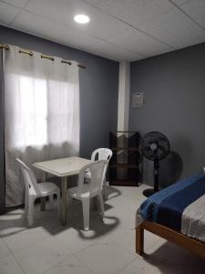 1 dormitorio con mesa, sillas y 1 cama en Departamento Elegante y acogedor hotel Económico, en La Libertad