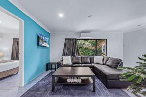 埃尔利海滩Airlie Sun & Sand Accommodation #6的客厅里有一张沙发和一张桌子。