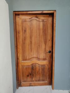 una puerta de madera en la esquina de una habitación en Departamento Elegante y acogedor hotel Económico, en La Libertad