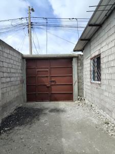 Un garaje con una puerta de garaje roja en un edificio. en Departamento Elegante y acogedor hotel Económico, en La Libertad