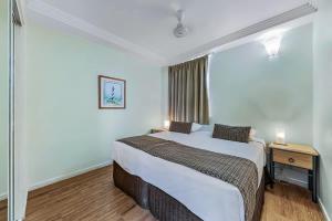 ein Schlafzimmer mit einem großen Bett und einem Nachttisch in der Unterkunft Marina views at Airlie 10F - 1 bedroom in Airlie Beach