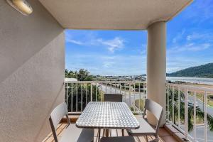 ein Balkon mit Tisch und Stühlen und Blick auf das Wasser in der Unterkunft Marina views at Airlie 10F - 1 bedroom in Airlie Beach