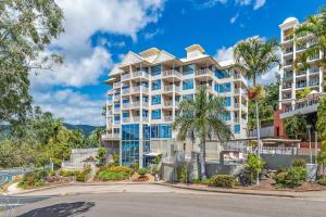 ein Apartmenthaus mit Palmen und einer Straße in der Unterkunft Marina views at Airlie 10F - 1 bedroom in Airlie Beach