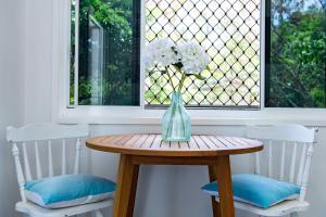 un vaso su un tavolo di legno davanti a una finestra di Seascape Whitsundays ad Airlie Beach