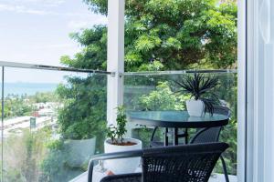 un balcone con tavolo e sedie e una finestra di Seascape Whitsundays ad Airlie Beach