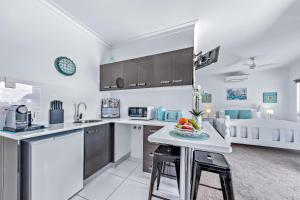una cucina con un tavolo con una ciotola di frutta sopra di Seascape Whitsundays ad Airlie Beach Altre 18 foto