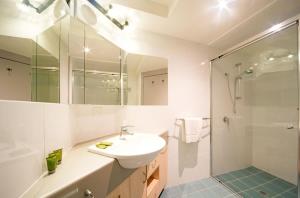 ein weißes Badezimmer mit Waschbecken und Dusche in der Unterkunft Baybliss Escape #1 - Adults Only in Shute Harbour