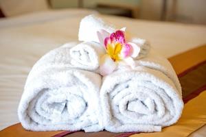 ein Paar Handtücher mit einer Blume auf dem Bett in der Unterkunft Baybliss Escape #1 - Adults Only in Shute Harbour + 31 Fotos