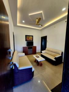 a living room with two couches and a tv at Kunjwan Resort in Bhor +21 photos