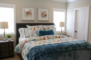 Un dormitorio con una cama con edredón azul y dos ventanas. en Destination #35, en Anaheim