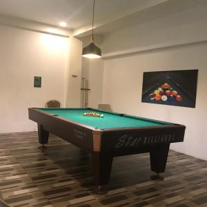 ein Billardtisch in einem Raum mit einem Gemälde von Früchten in der Unterkunft Exclusive Family Villa in Sampong