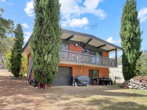 ein Backsteinhaus mit einem Balkon auf dem Dach in der Unterkunft Doon It Right in Bonnie Doon