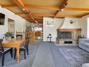 ein Wohnzimmer mit einem Tisch und einem Kamin in der Unterkunft Doon It Right in Bonnie Doon