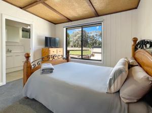ein Schlafzimmer mit einem großen Bett und einem großen Fenster in der Unterkunft Doon It Right in Bonnie Doon