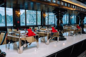un restaurante con mesas y sillas con asientos rojos en Bonita Halong Cruise, en Cat Ba
