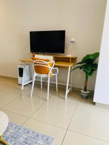 ein Schreibtisch mit einem Fernseher und einem Stuhl in einem Zimmer in der Unterkunft Cozy Mellenial Umhlanga studio in Durban + 27 Fotos
