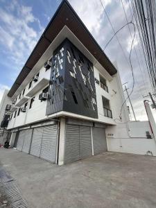 a large white building with two garage doors at Stay Inn Apartelle in Roxas City