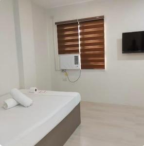 a white room with a bed and a window at Stay Inn Apartelle in Roxas City