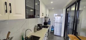 a kitchen with white cabinets and a white refrigerator at Alba Gardens in Gatunga
