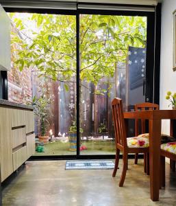Un comedor con una ventana con vista a un árbol. en Apartamento Loft cerca del aeropuerto, en Cúcuta