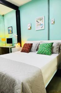 1 dormitorio con cama blanca y almohadas coloridas en Apartamento Loft cerca del aeropuerto, en Cúcuta