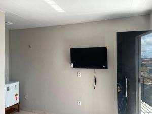 a flat screen tv hanging on a wall at Suites no Atalaia in Salinópolis
