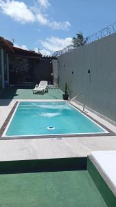 a swimming pool with a chair next to a house at Hostel dos amigos in Salinópolis
