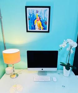 escritorio con monitor de ordenador y lámpara en Apartamento Loft cerca del aeropuerto, en Cúcuta