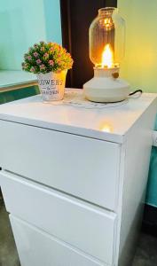 a lamp on top of a white dresser with a plant at Loft ejecutivo con Aire Acondicionado, cerca de Clinica Duarte y UFPS in Cúcuta