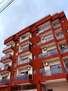 アビジャンにあるRésidence KS Ephrataの赤い建物(バルコニー付)