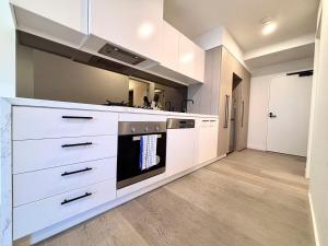 北克莱顿M-City Cozy Cloud Apartment near Hospitable&Monash的厨房配有白色橱柜和炉灶。
