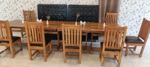 a wooden dining room table with chairs and a wooden table and chairsktop at Hotel Annapurna Regency in Mirzāpur