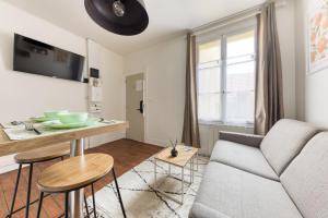 ein Wohnzimmer mit Sofa und Tisch in der Unterkunft L'élégance - La Petite Provence & La belle époque - hyper centre in Dreux