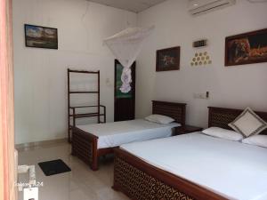 a room with two beds and a ladder on the wall at Walawa cottage udawalawe in Udawalawe