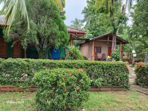 a house with a hedge in front of a house at Walawa cottage udawalawe in Udawalawe