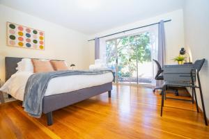ein Schlafzimmer mit Bett, Schreibtisch und Fenster in der Unterkunft Central 3BR Home Steps from Castro St in Mountain View