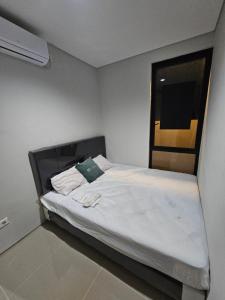 Posto letto in una piccola camera con finestra di Omah Bubuya Syariah, Surabaya barat 