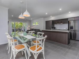 una cucina e un soggiorno con tavolo e sedie di Dianella Dunes a Casuarina