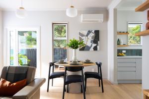 a kitchen and dining room with a table and chairs at Nelson Bridge House in Nelson