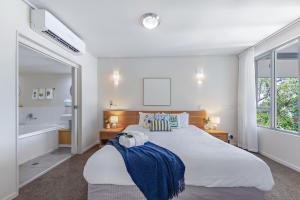 una camera da letto con un letto grande e una vasca da bagno di Amalfi Whitsunday Retreat Infinity Pool SeaViews ad Airlie Beach