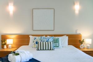 una camera da letto con un letto con cuscini blu e bianchi di Amalfi Whitsunday Retreat Infinity Pool SeaViews ad Airlie Beach