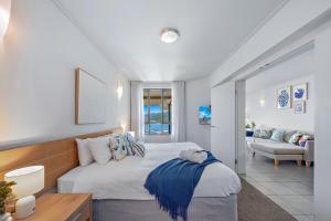 una camera da letto con un letto e un soggiorno di Amalfi Whitsunday Retreat Infinity Pool SeaViews ad Airlie Beach