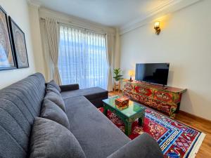 ein Wohnzimmer mit einer blauen Couch und einem Fernseher in der Unterkunft Shama suites in Kathmandu + 23 Fotos