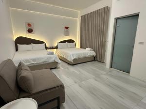 una habitación de hotel con dos camas y un sofá en Yunheyue B&B, en Suao