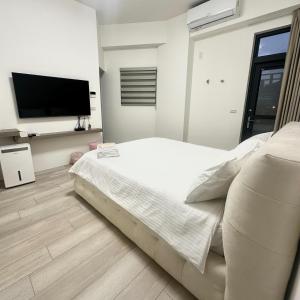 Un dormitorio con una cama y un televisor de pantalla plana. en Yunheyue B&B, en Suao